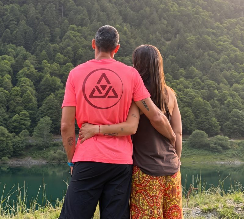 Roger y su mujer abrazados de espaldas frente a un lago de montaña