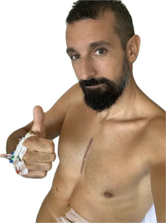 Roger con el pulgar arriba, la vía en la mano y la cicatriz en el pecho